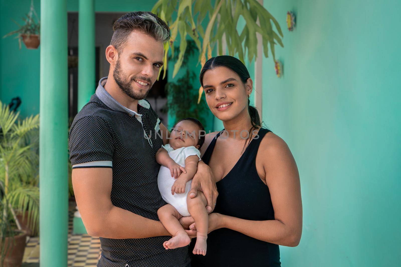 Photo of a baby in the arms of a woman and a man