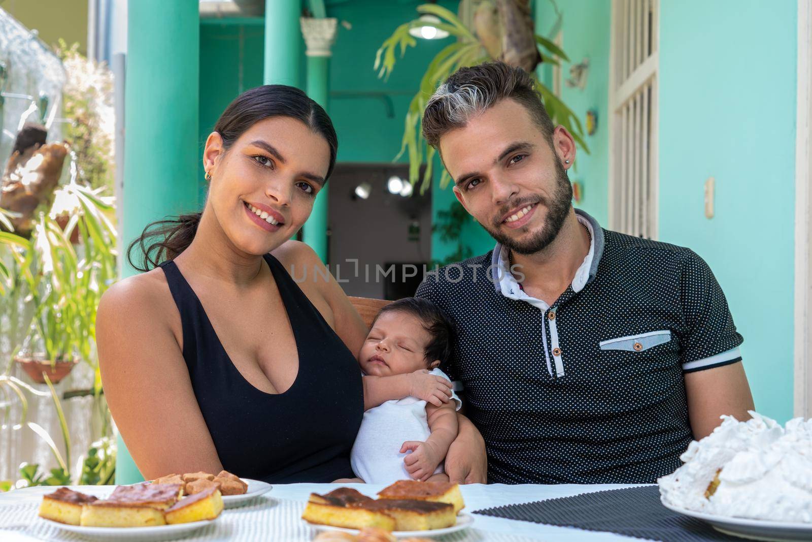 Photo of a baby in the arms of a woman and a man