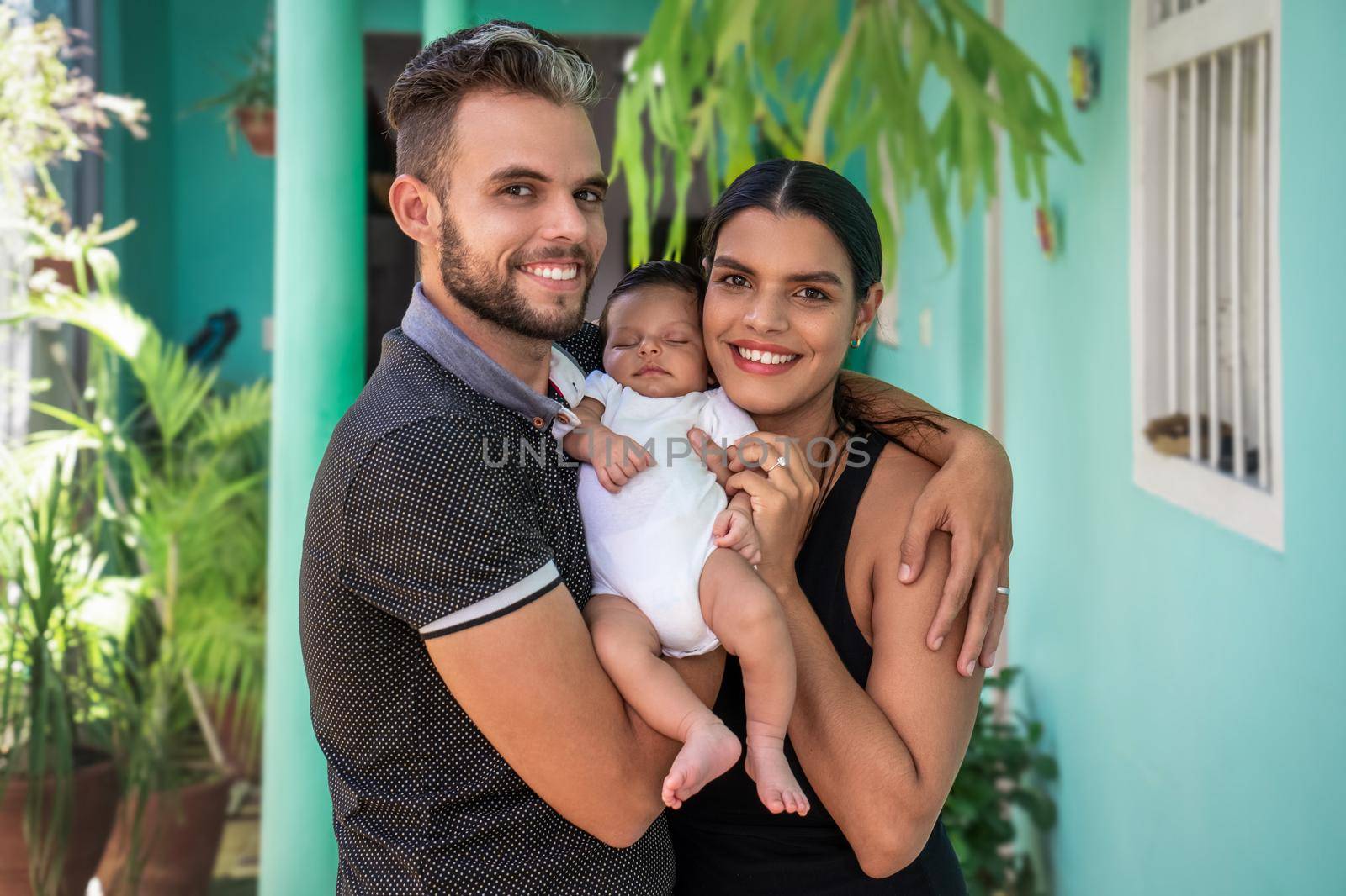 Photo of a baby in the arms of a woman and a man