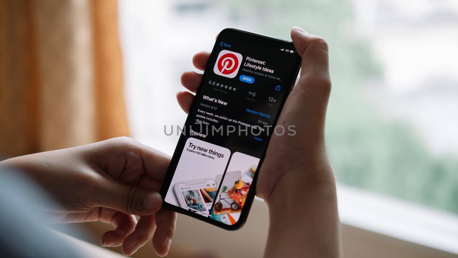 CHIANG MAI,THAILAND - APR 18,2020 : Woman using iPhone X with social Internet Pinterest application on the screen. Pinterest is an online pinboard that allows people to pin their.