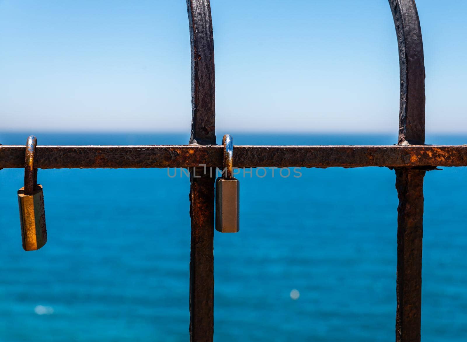 rusty padlock attached to a balustrade by the sea, a traditional way of showing love, relationship