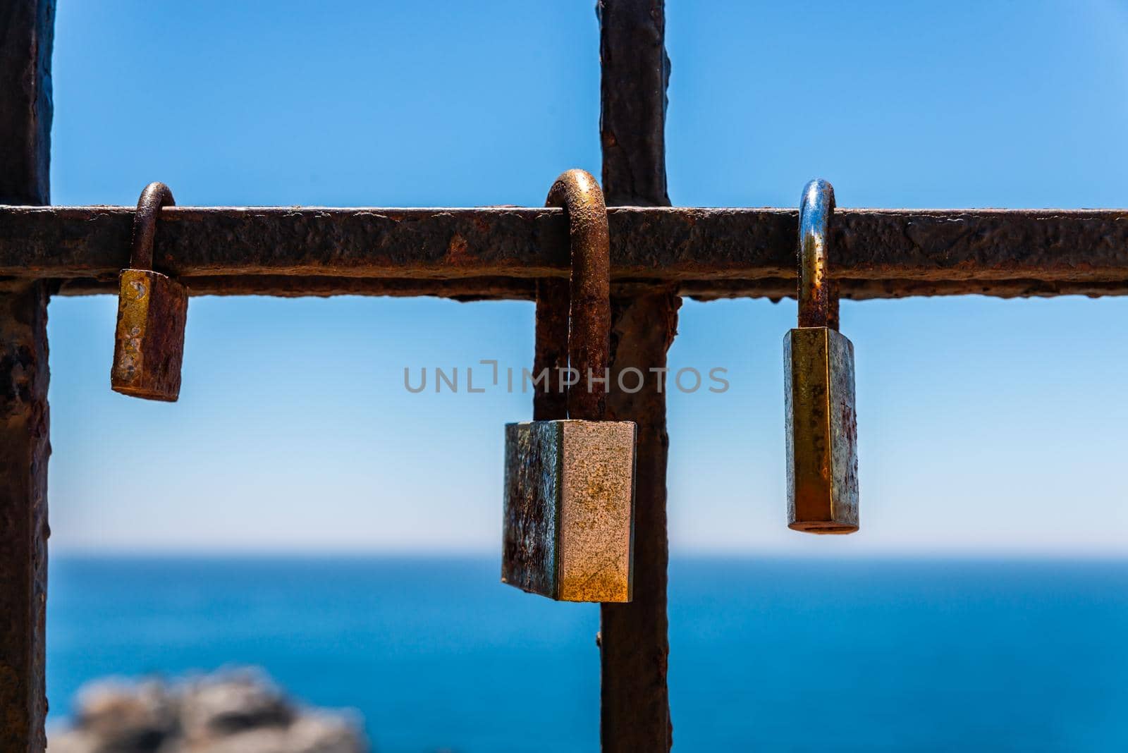 rusty padlock attached to a balustrade by the sea, a traditional way of showing love, relationship