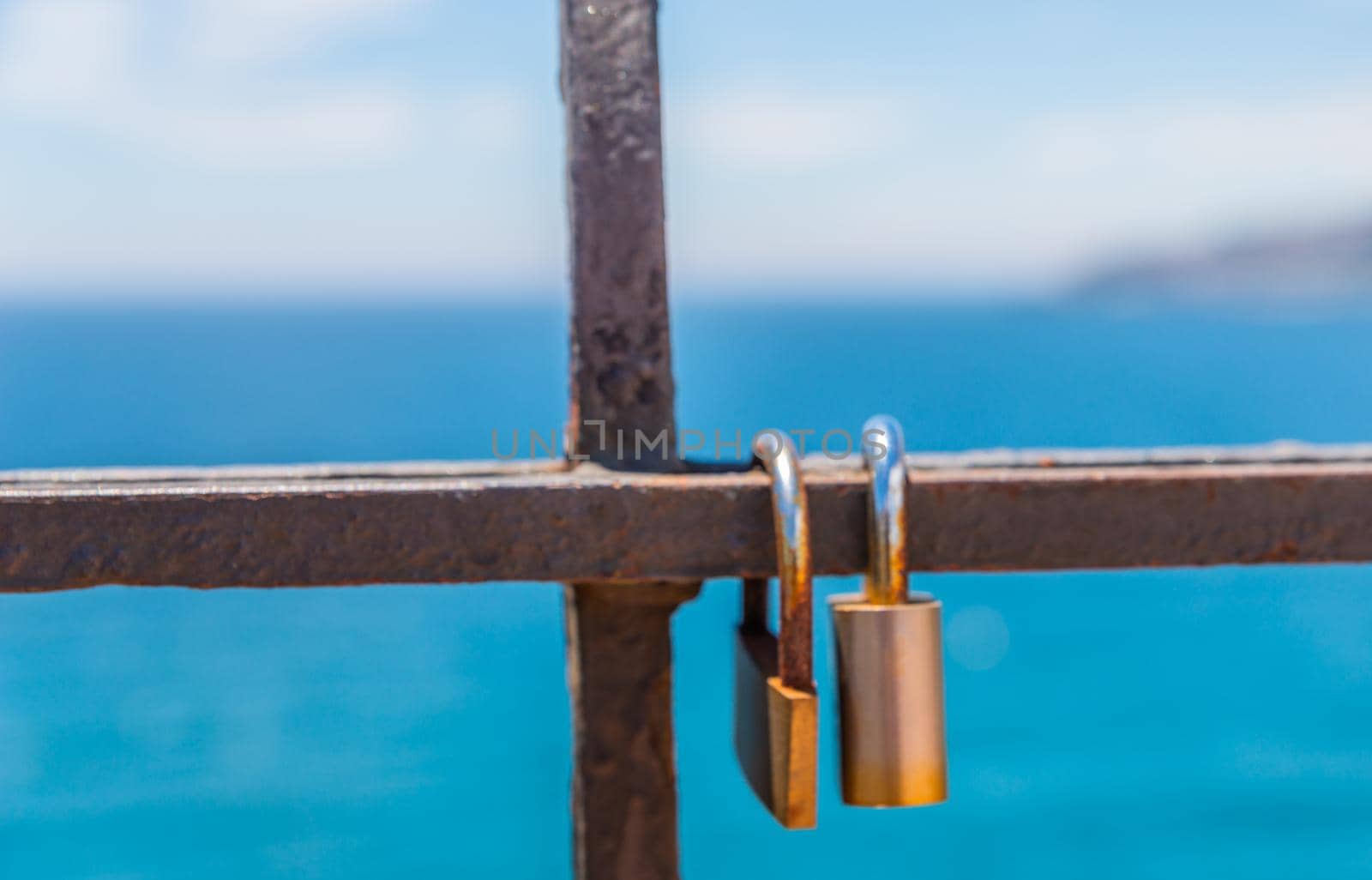 rusty padlock attached to a balustrade by the sea, a traditional way of showing love, relationship