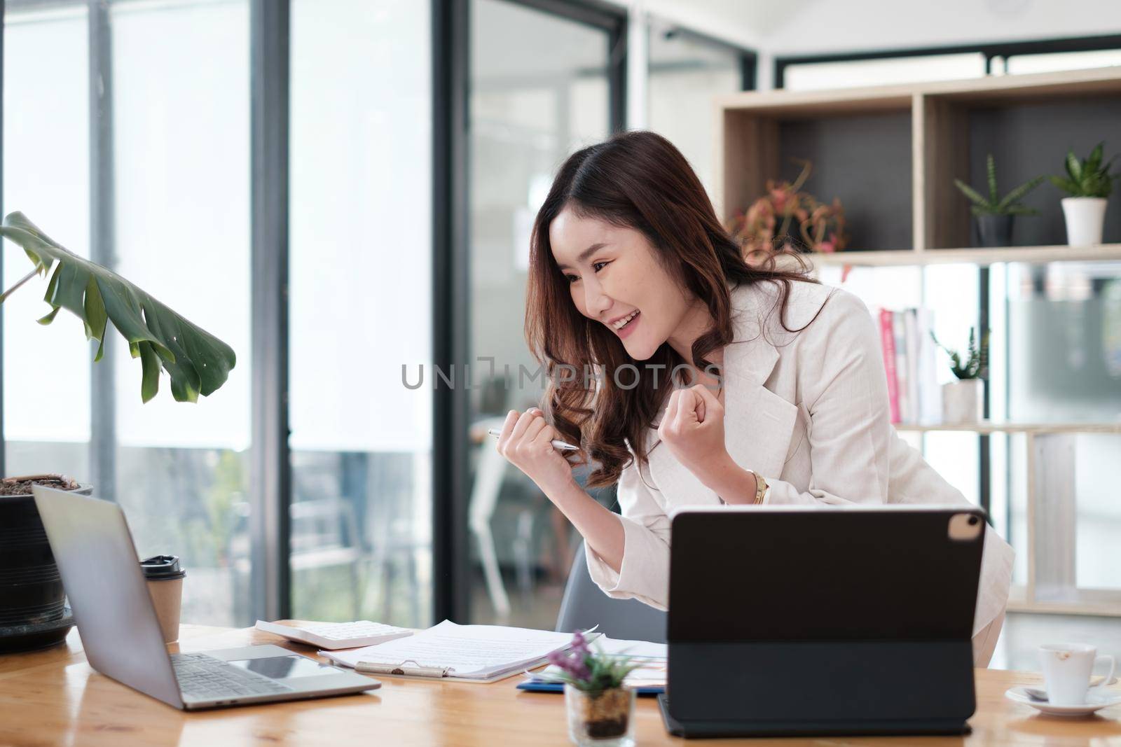 Asian Woman blogger wear white suit exciting and talking with followers, live streaming on social media application. Freelance work from home concept. by itchaznong