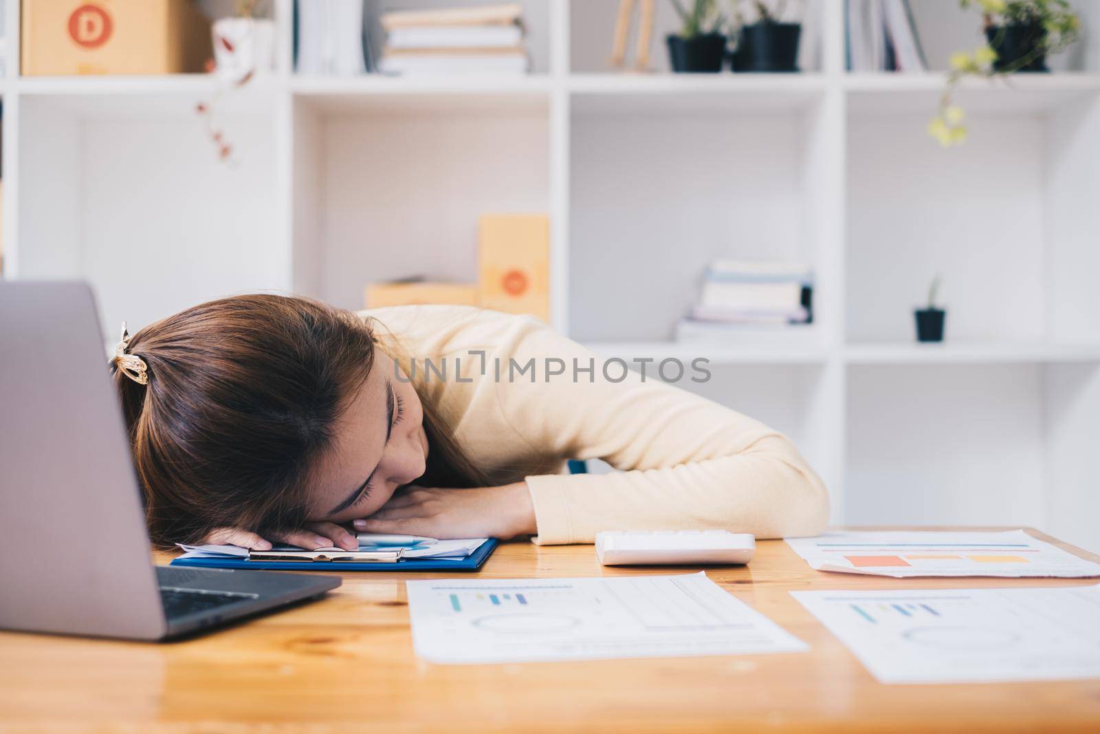 Asian business woman sleeping on table after hard work to audit transactions account budget of company. Accountant and Anti Bribery concept. by itchaznong