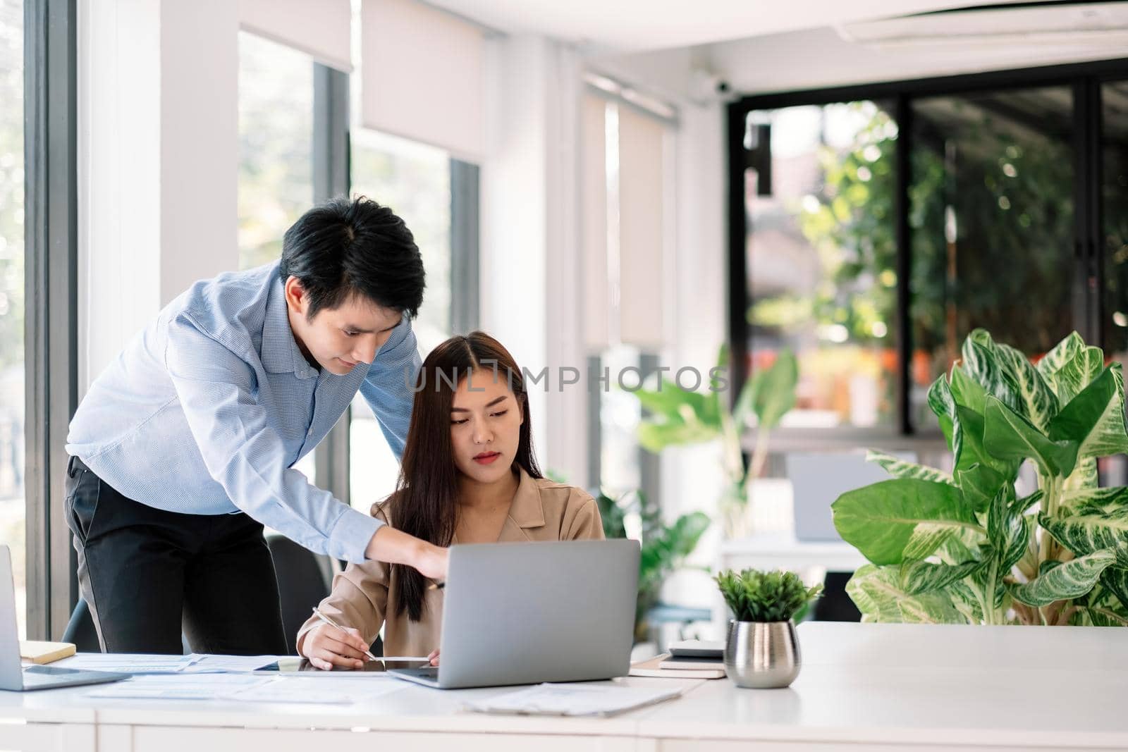 Entrepreneur Asian businessman and woman discussing new business project in laptop computer in modern meeting room