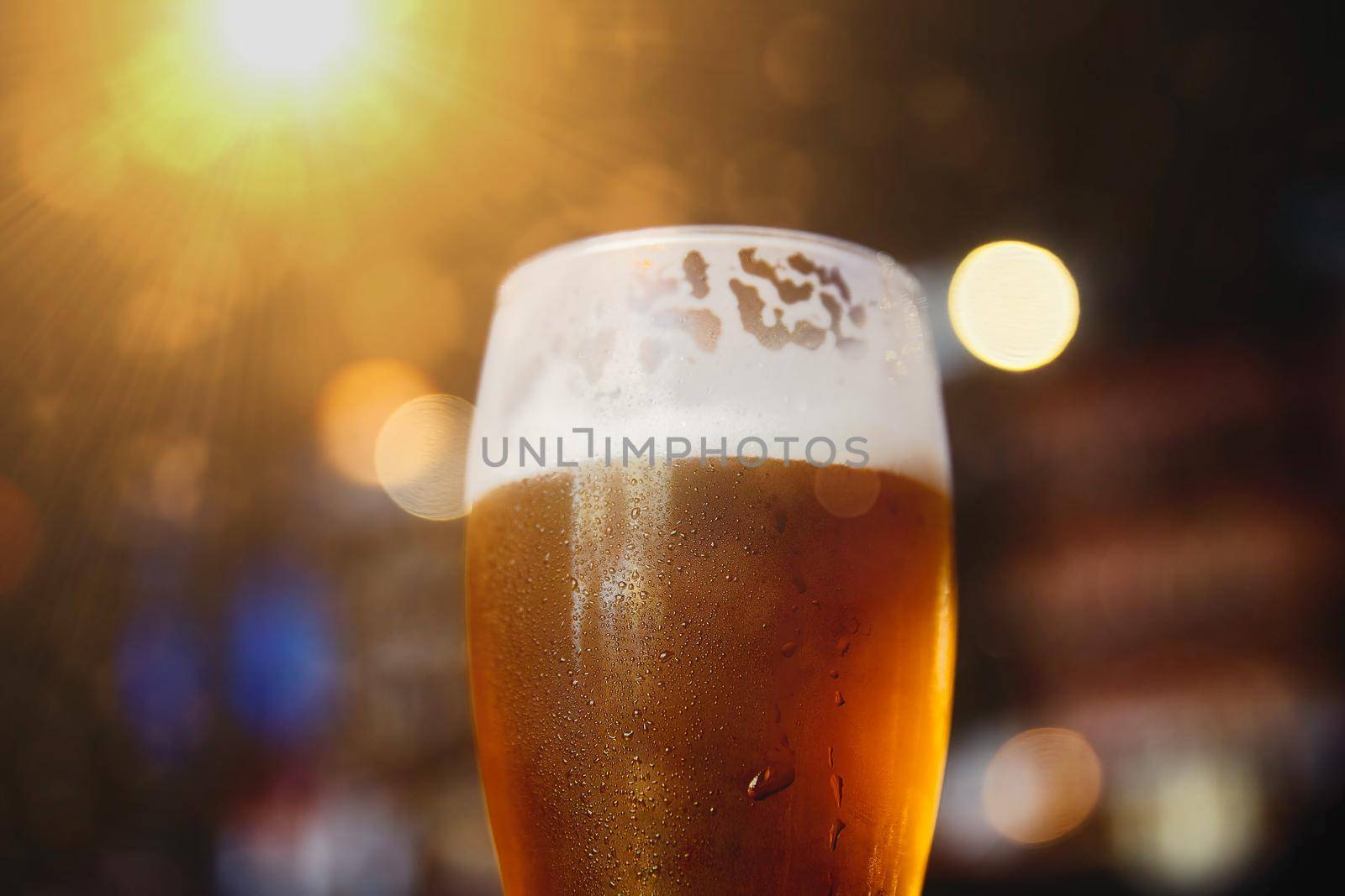 Glass of beer on a table in a bar on blurred bokeh background by EvgeniyQW