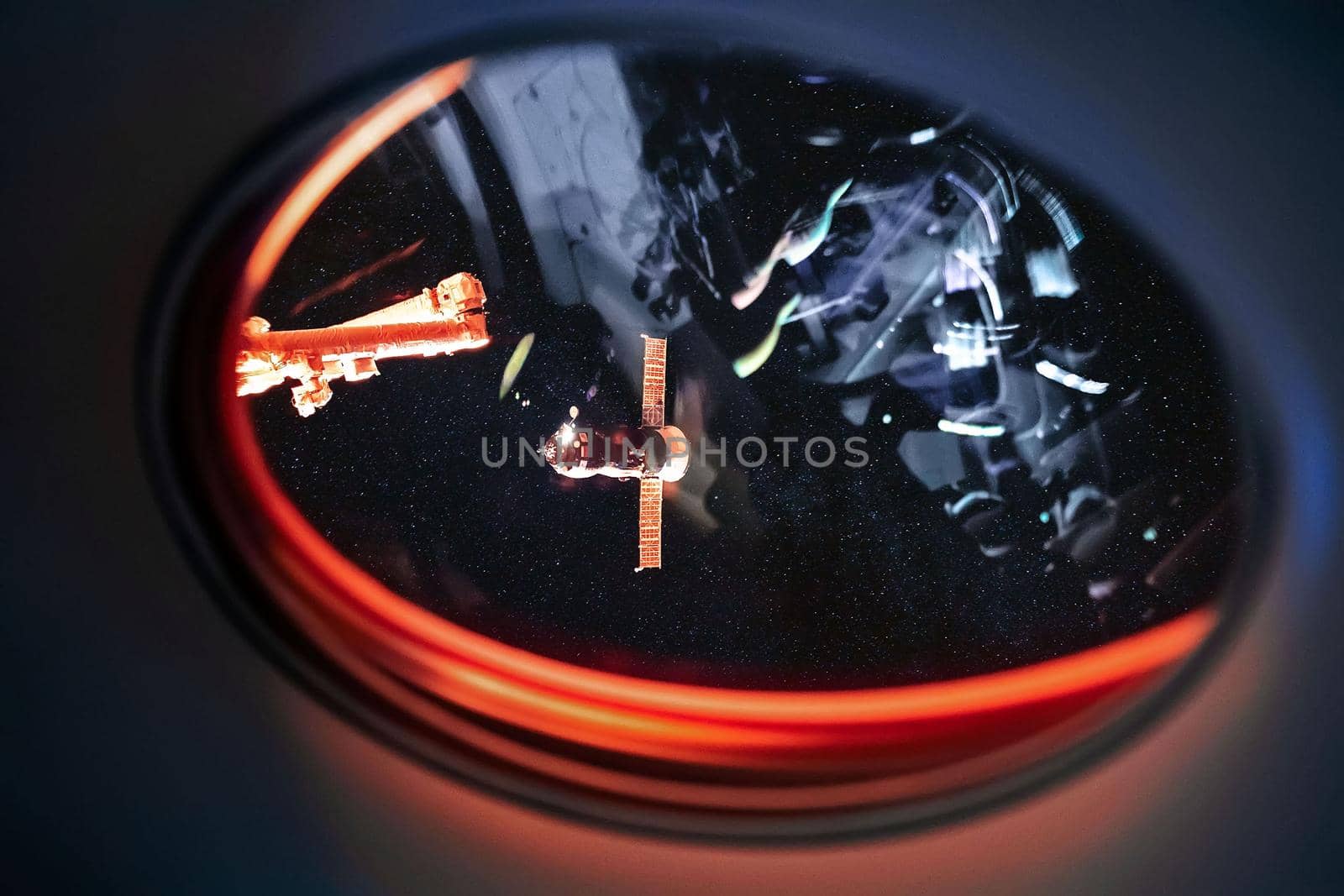 View on ISS Progress resupply ship, View out from a passenger window on the SpaceX Crew Dragon. Docking maneuver near the Space Station. Elements of image furnished by NASA.