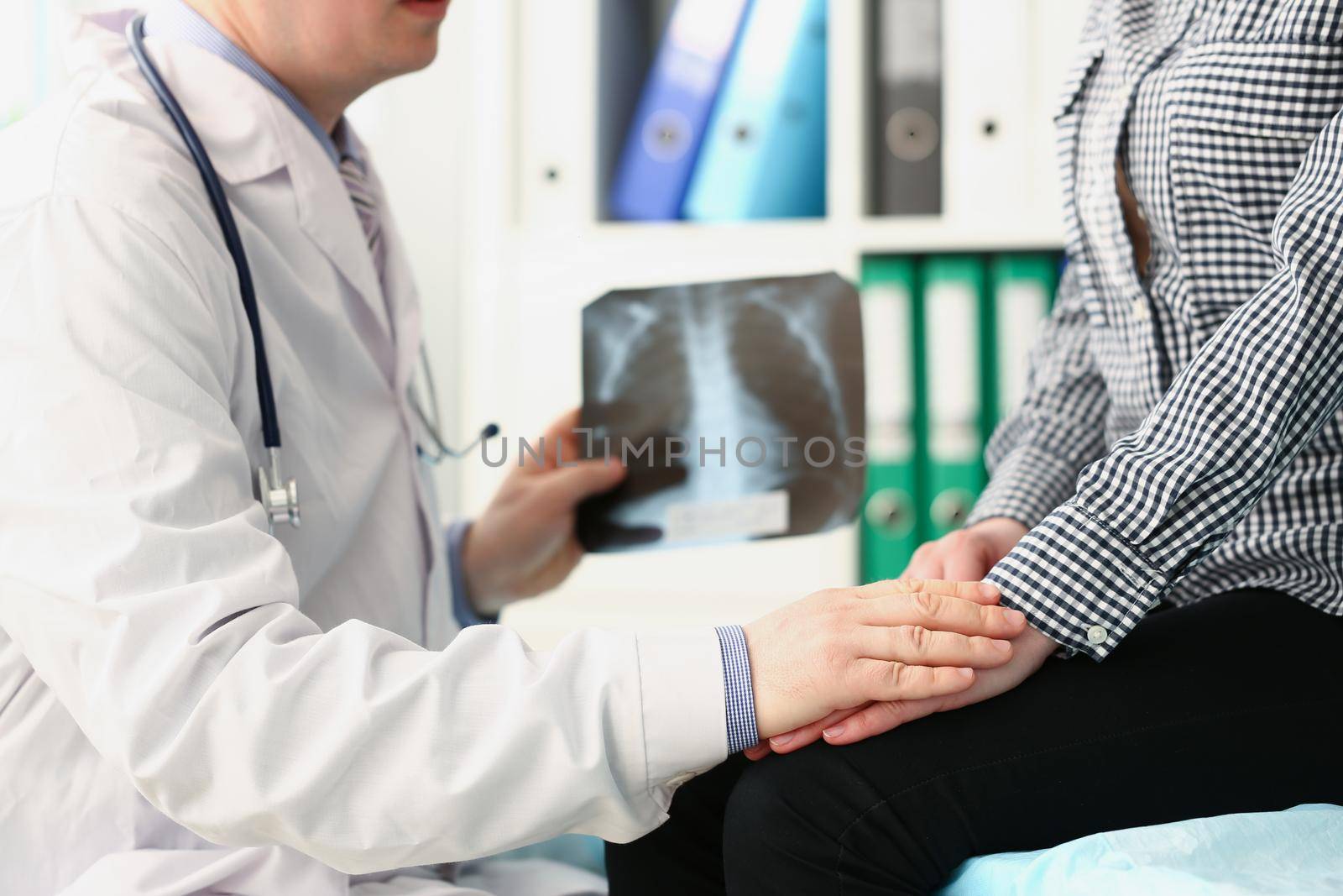 Close-up of qualified male doctor hold x ray scan of patients lungs and talk to client. Medical worker prescribe full diagnostic for woman. Disease concept