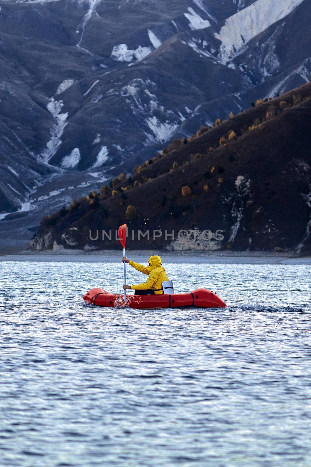 Swim in Packraft. Packraft, one-person light raft used for expedition or adventure racing, on a lake, inflatable boat Ride on a mountain lake by EvgeniyQW