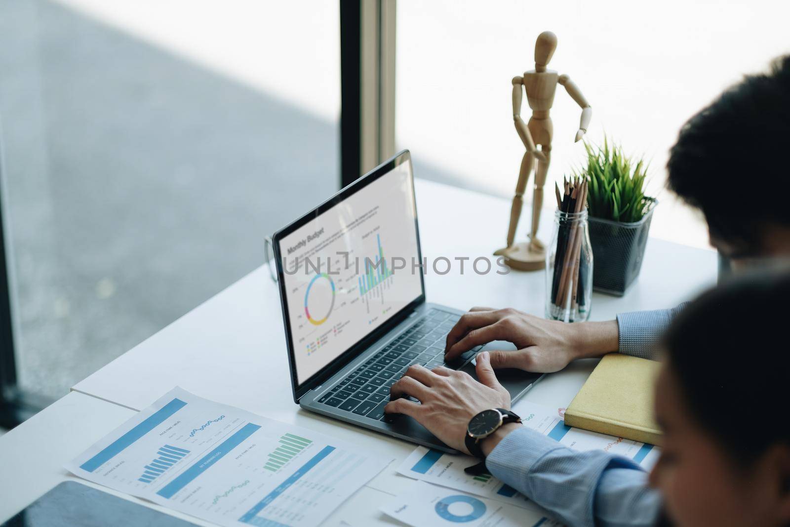 Businessman work with laptop at office, typing on keyboard. financial paperwork chart graph on desk.