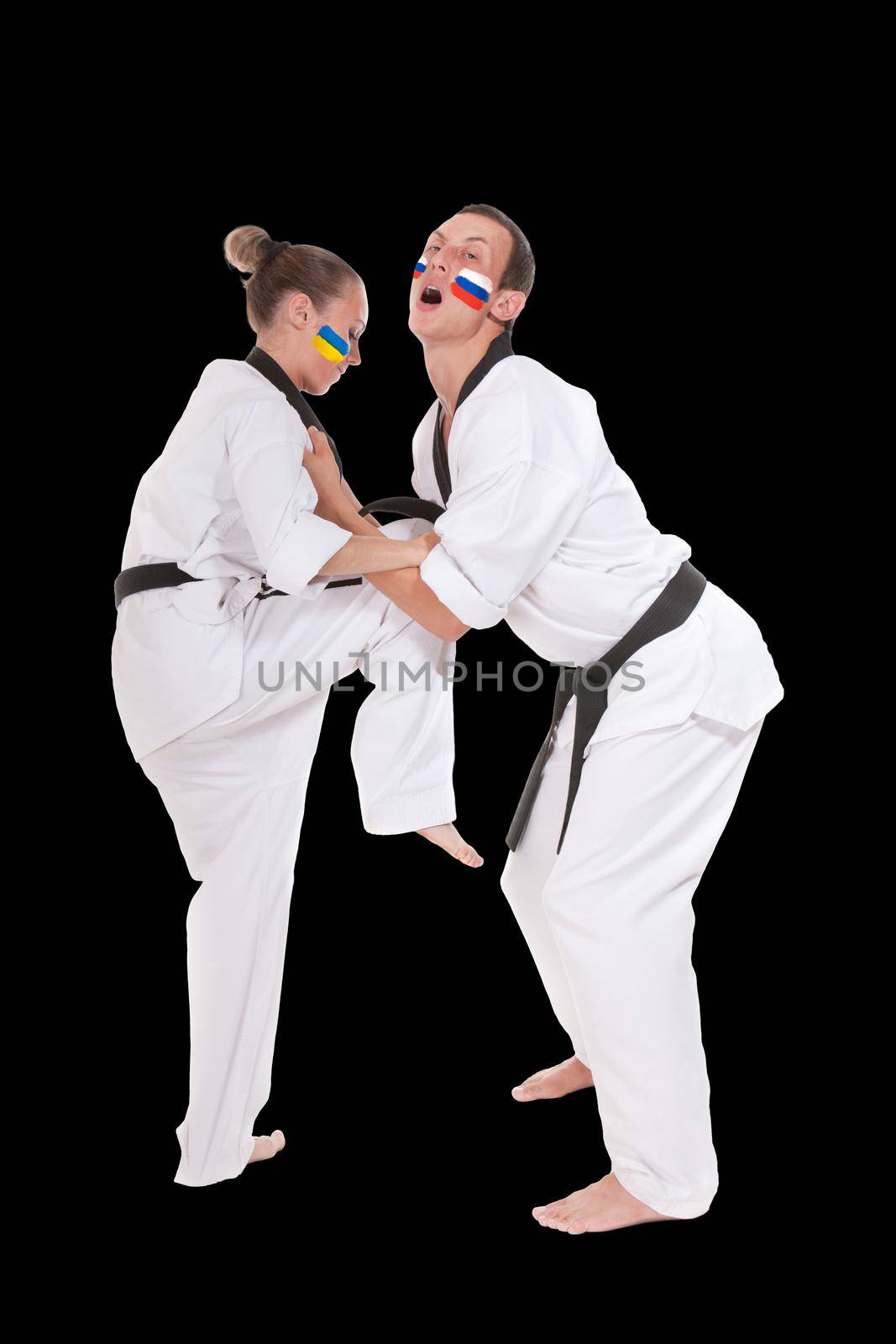 Defense kick of Ukraine and Russia two fighting representatives of different countries. Woman make ankle kick to a man, two fighting people isolated on black background.