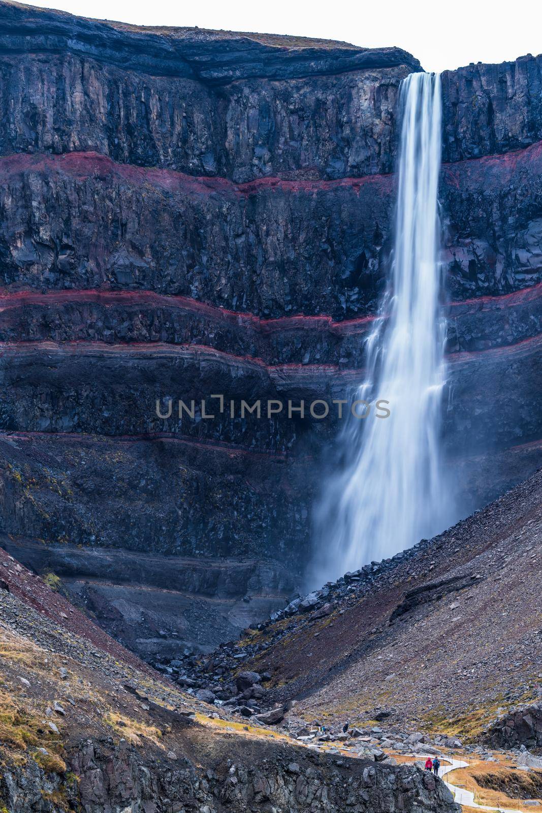 Hengifoss waterfall vertical composition long exposure with hiking track and blurred tourists