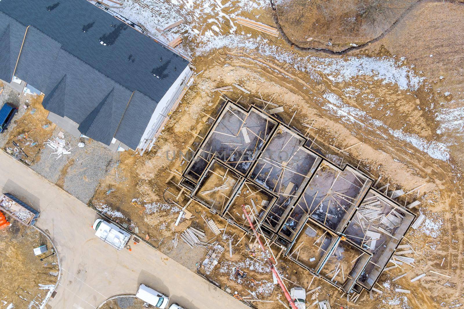 Aerial view on the preparation of the work for unfinished with foundation to new house construction in the suburbs by ungvar
