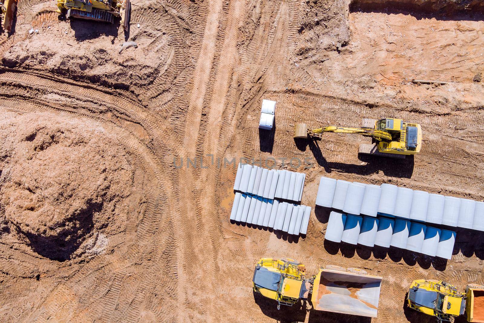 Aerial view with preparation of the land for the construction on new concrete circular pipes lying down for the sewerage system a new building
