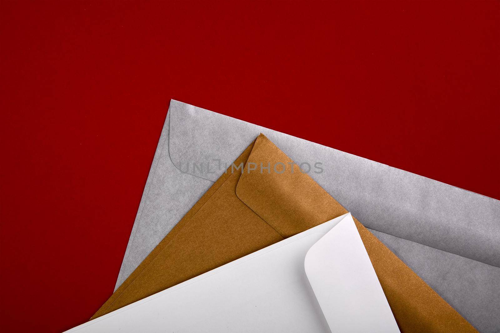 Photo of blank envelopes on a red background. Template for branding identity. Envelopes mockup. White paper isolated on red. Top view. by EvgeniyQW