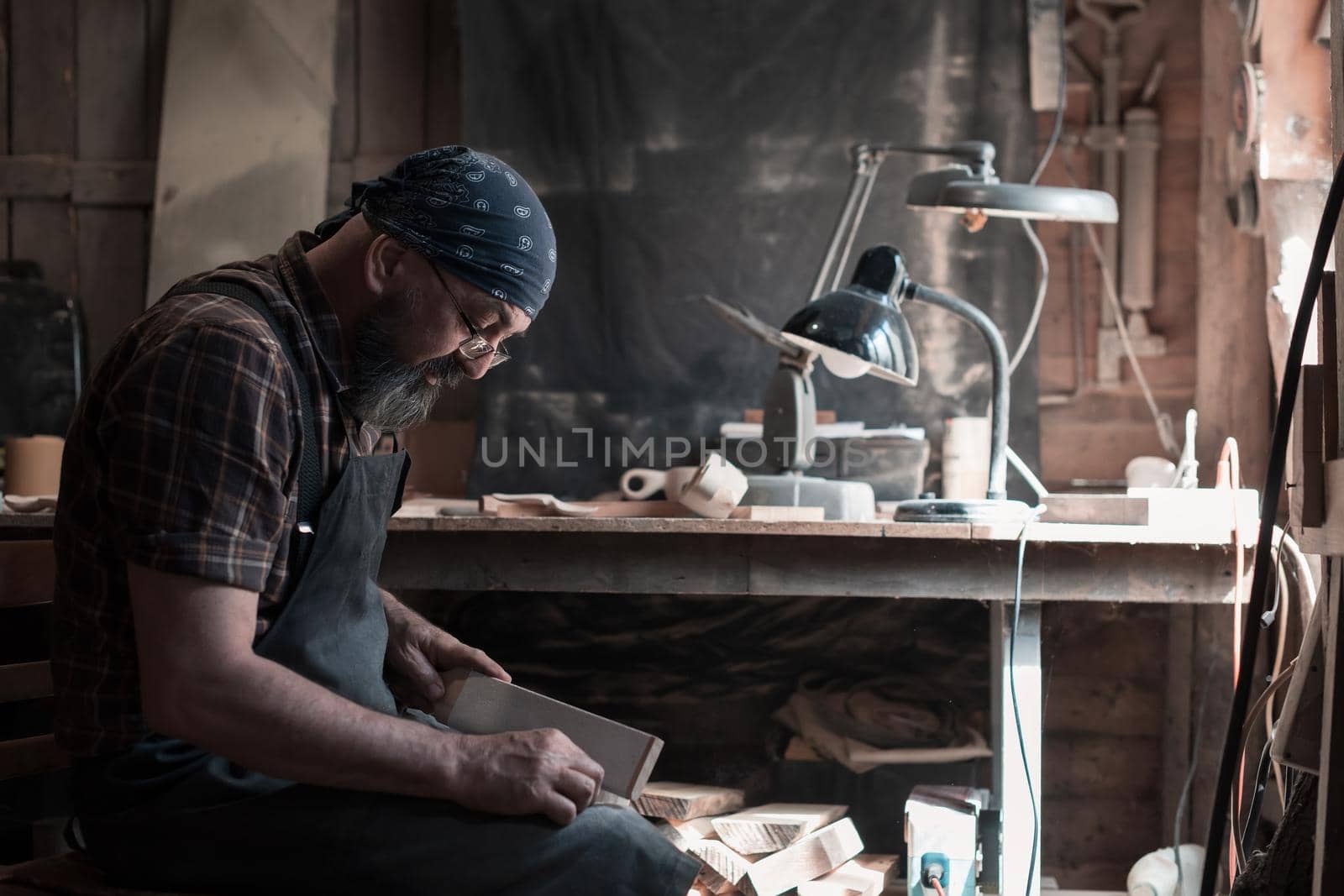 Spoon master in his workshop with wooden products and tools. High quality photo