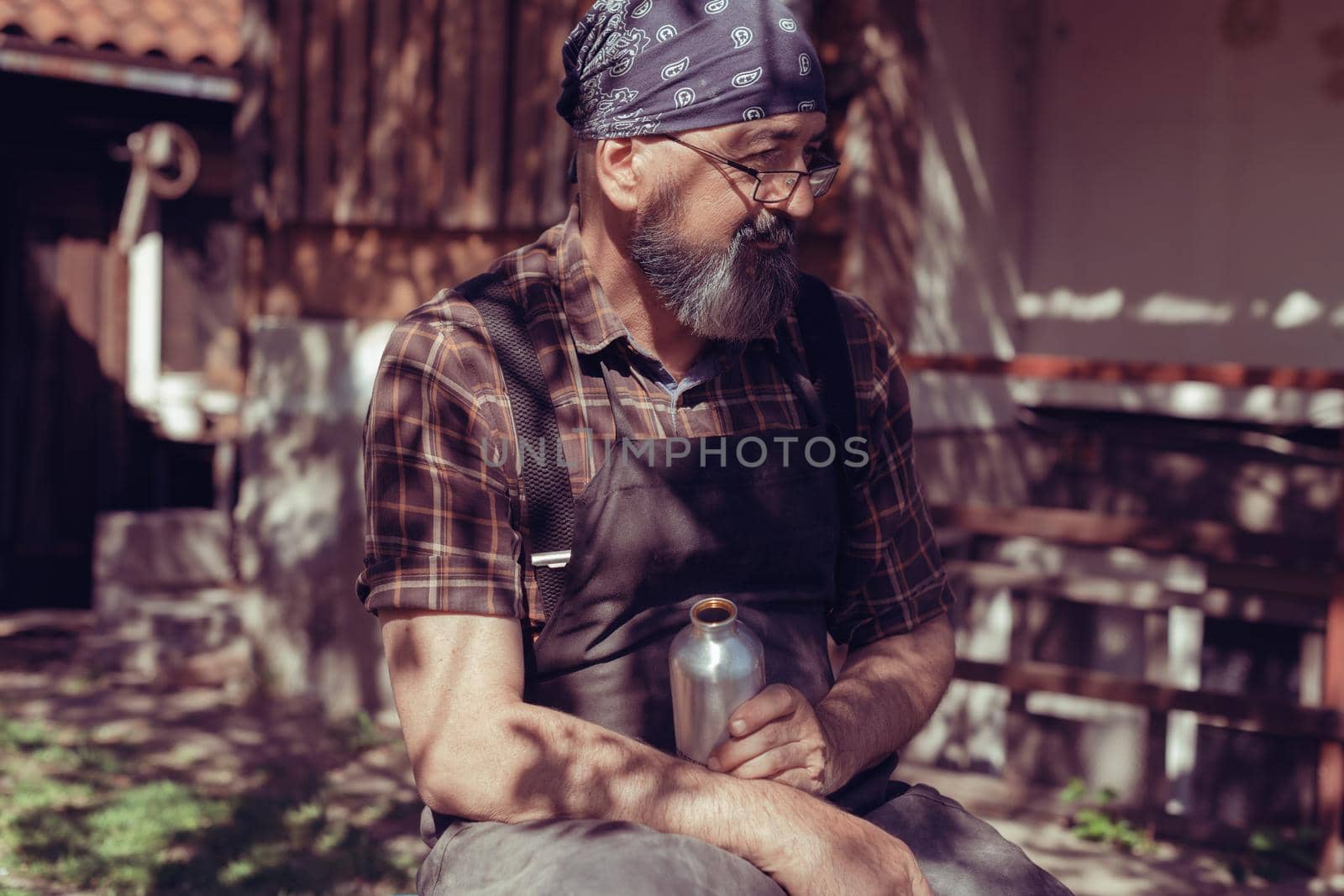 Spoon master in his workshop with wooden products and tools by dotshock