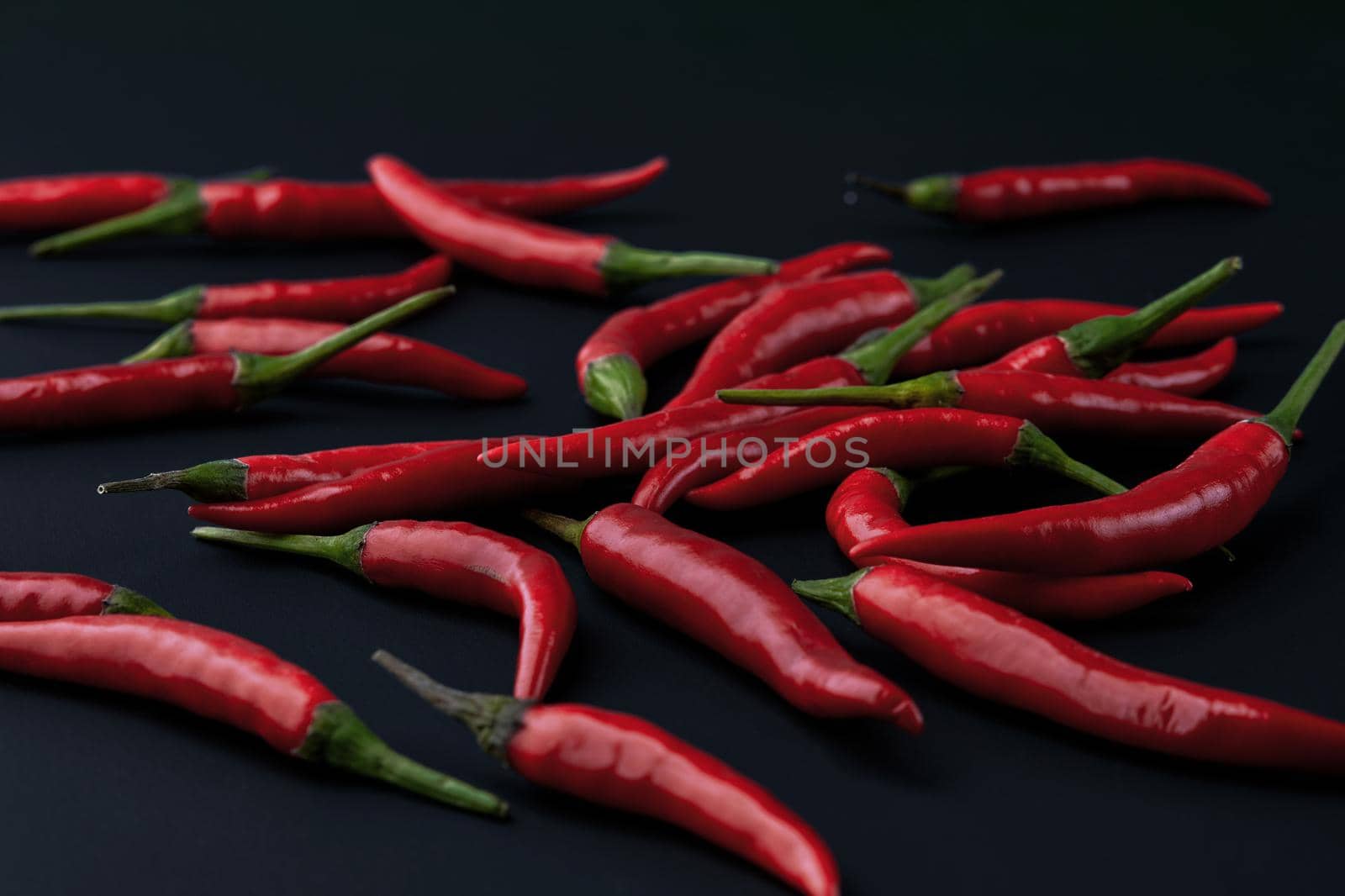 Red hot chili pepper on black background. Seasoning for real men. Fire seasoning by EvgeniyQW
