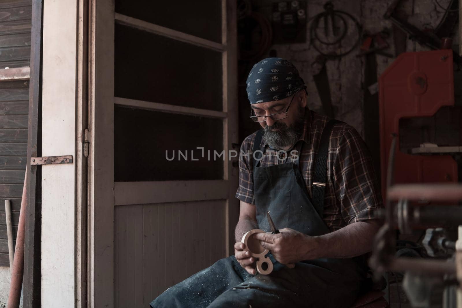 Spoon craft master in his workshop with handmade wooden products and tools working. High quality photo