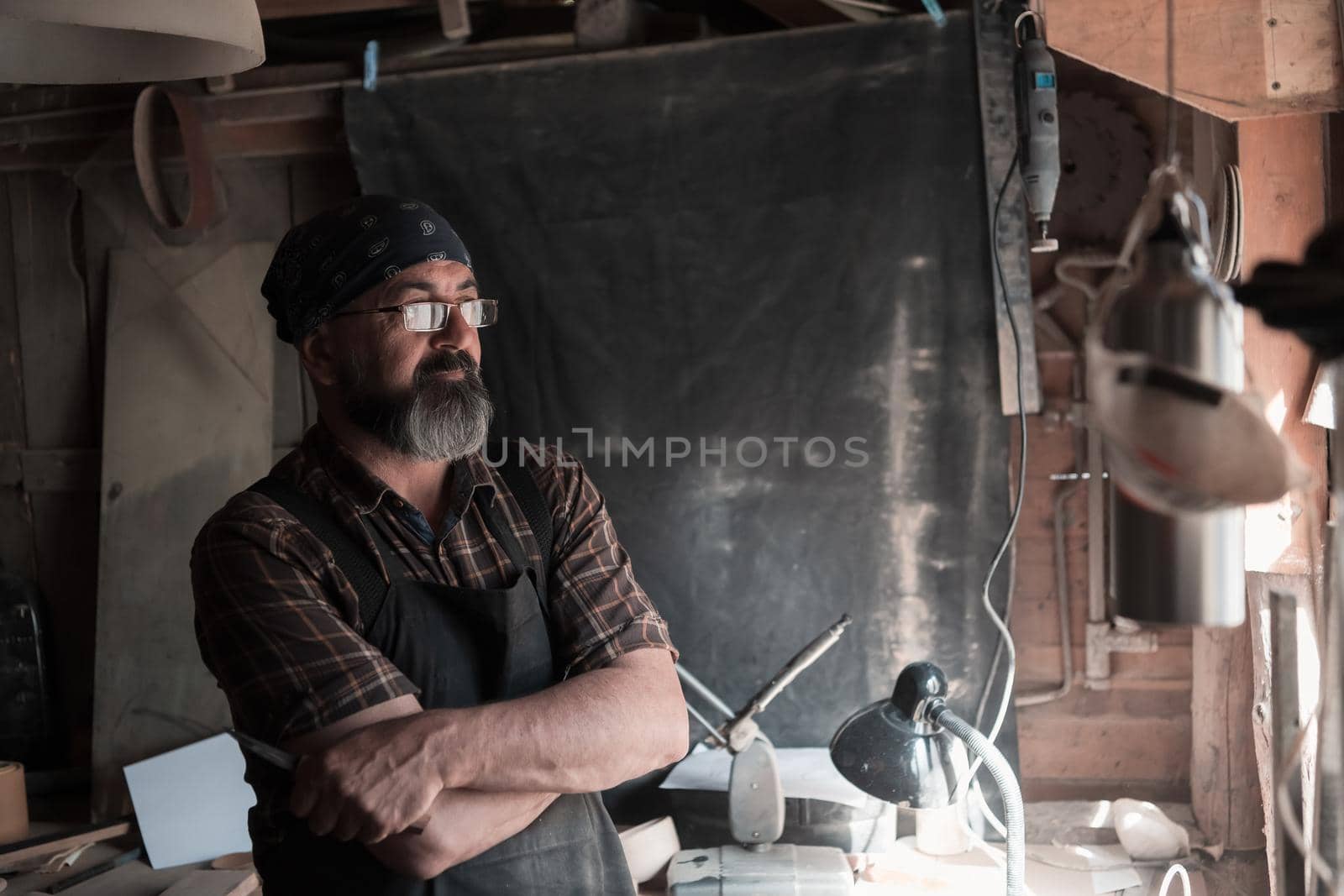 Spoon craft master in his workshop with handmade wooden products and tools by dotshock