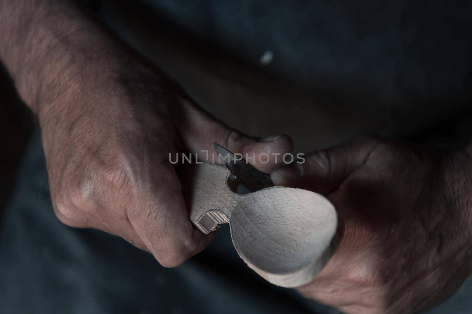 Spoon craft master in his workshop with handmade wooden products and tools working by dotshock