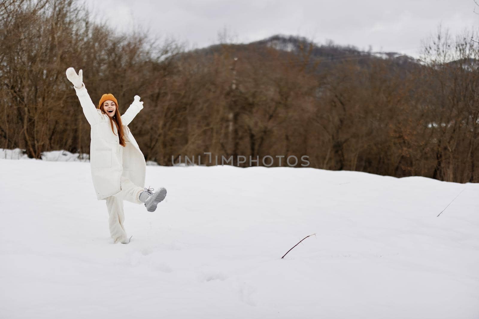 young woman in winter clothes in hats outdoors There is a lot of snow around by SHOTPRIME