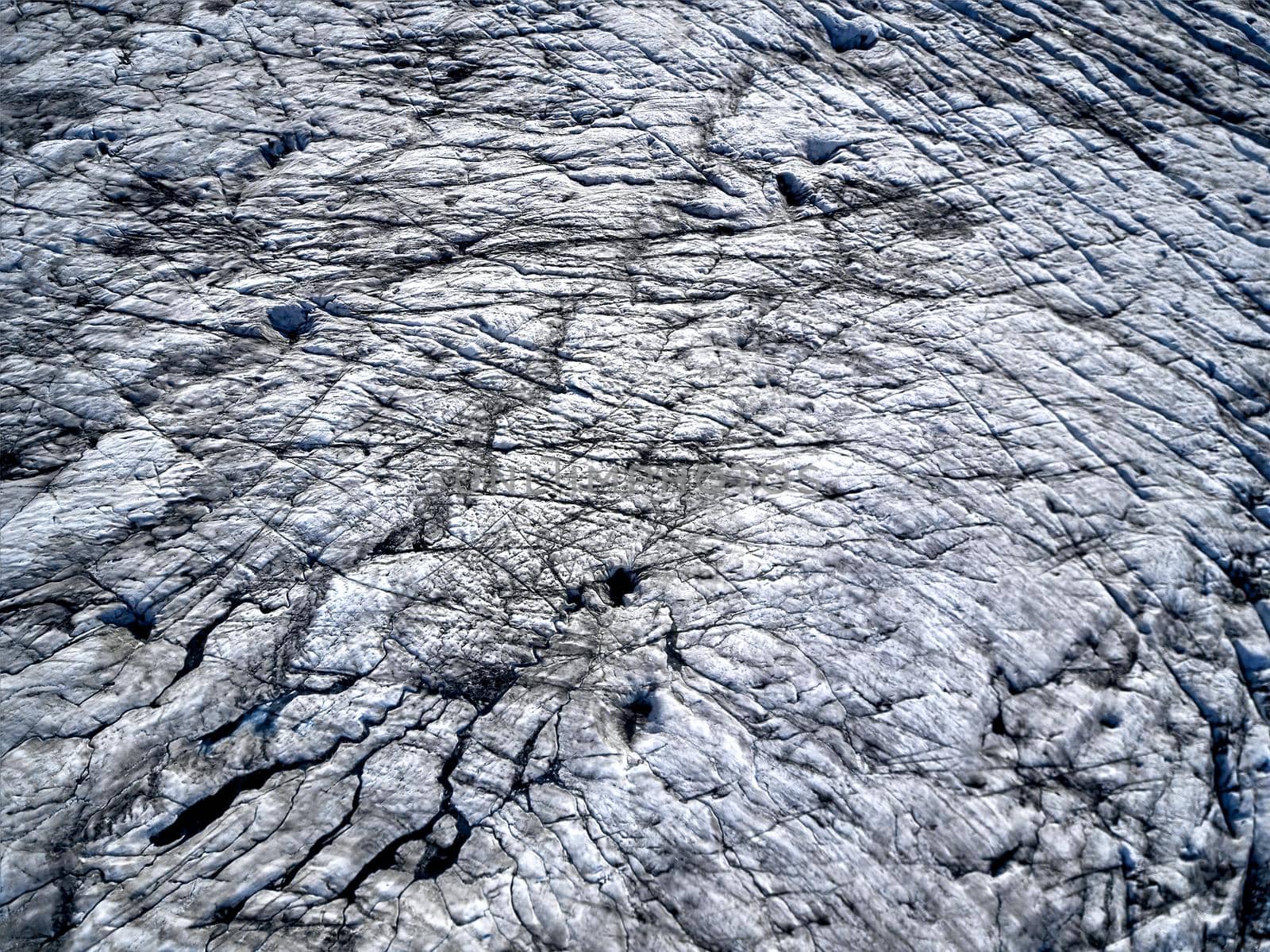 Aerial view of glacier from above, ice and ashes of the volcano texture landscape, beautiful nature ice background from Iceland