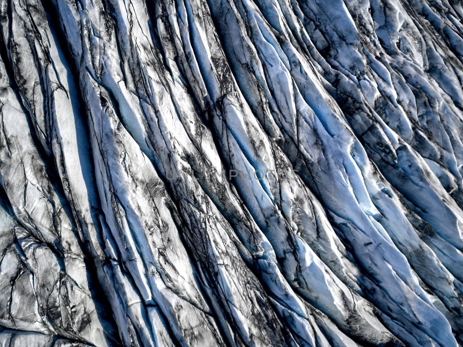 Aerial view of glacier from above, ice and ashes of the volcano texture landscape, beautiful nature ice background from Iceland