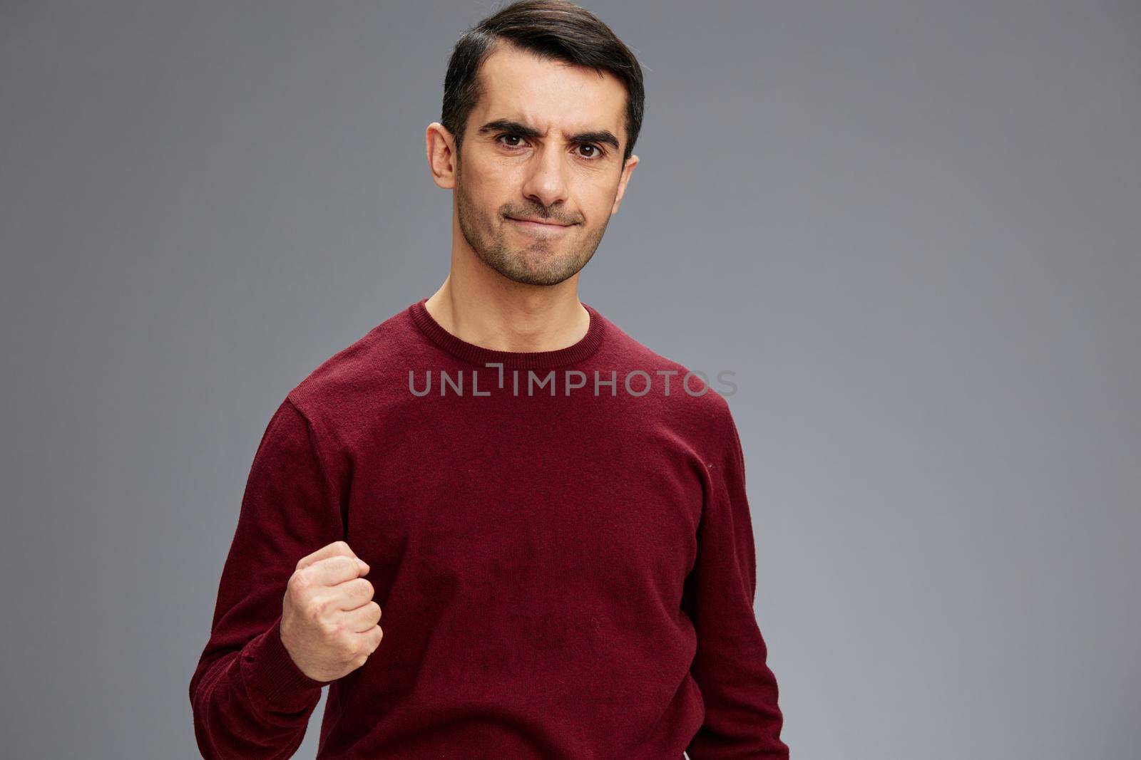 manager angry look clenched fist posing gesture with hands red sweater isolated background. High quality photo