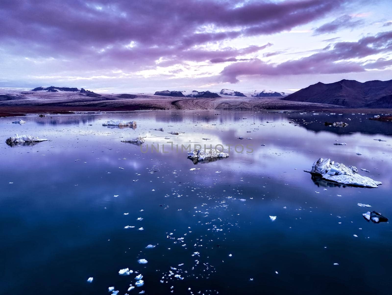 Aerial view of Glacier lagoon in Iceland during the sunrise. Ice floes calved from the glacier. melting ice