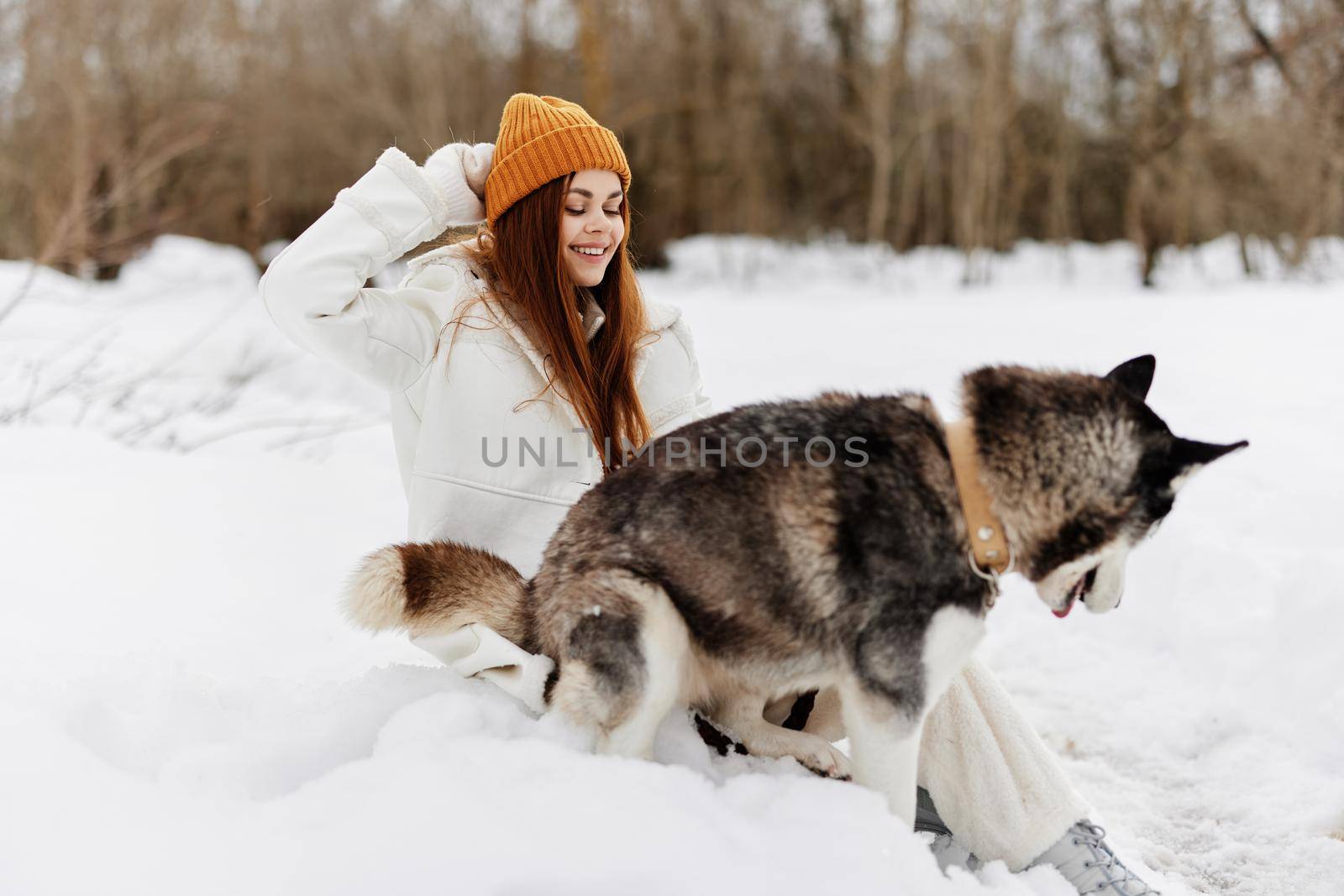 young woman in the snow playing with a dog fun friendship winter holidays by SHOTPRIME