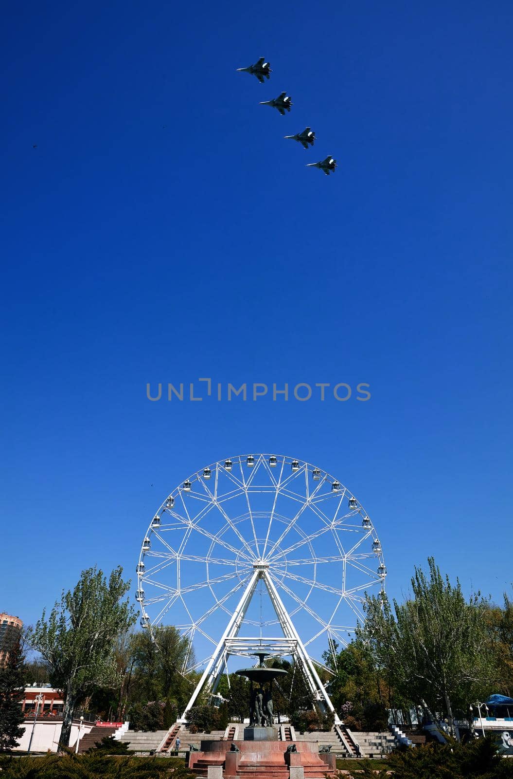 Rehearsal of the air parade in honor of the 75th anniversary of the end of World war II. Flying aircraft on the background of the Ferris wheel on theater square. 30.04.2020, Rostov-on-Don, Russia. by EvgeniyQW