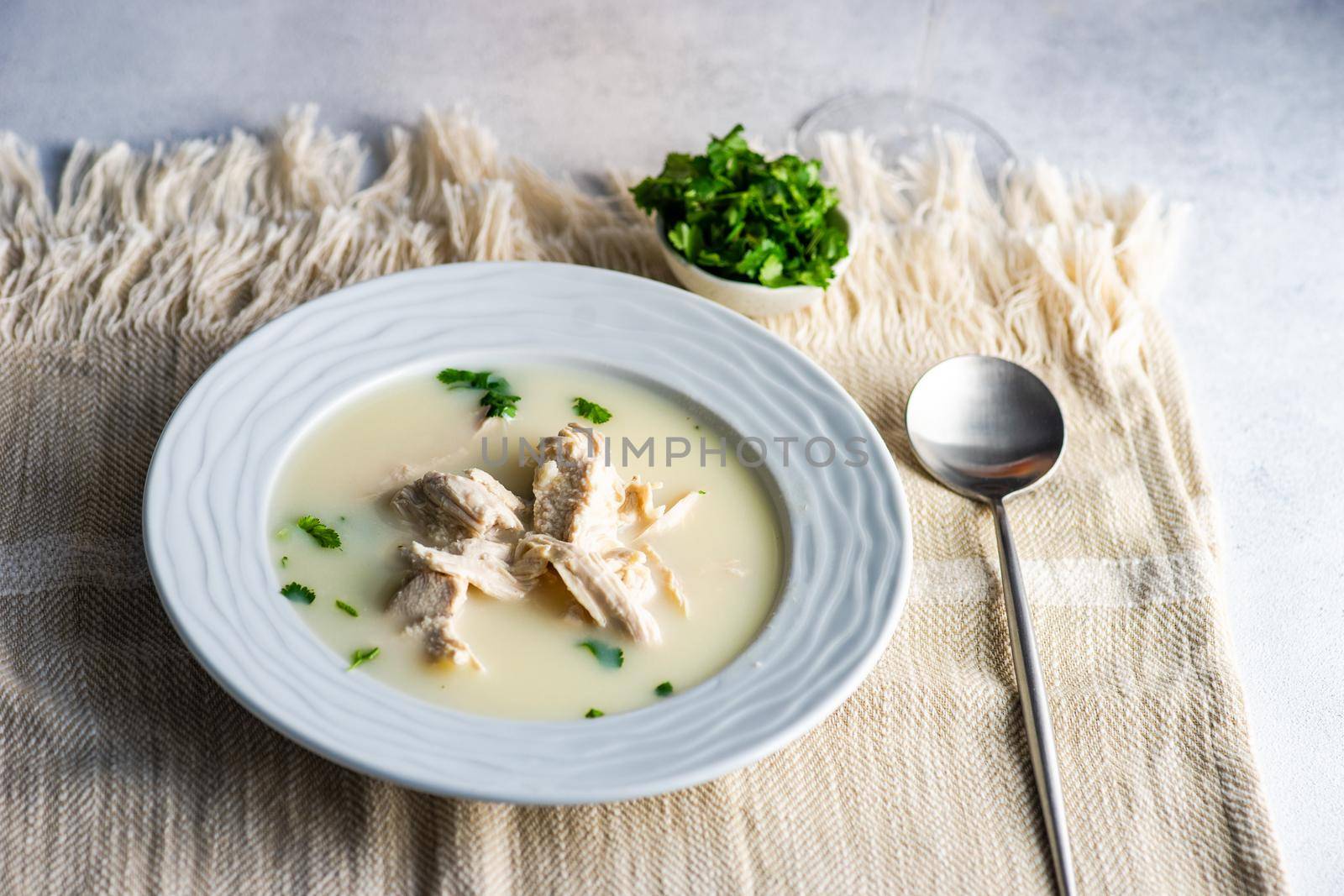 Traditional georgian chicken soup Chikhirtma served in ceramic bowl with coriander herb