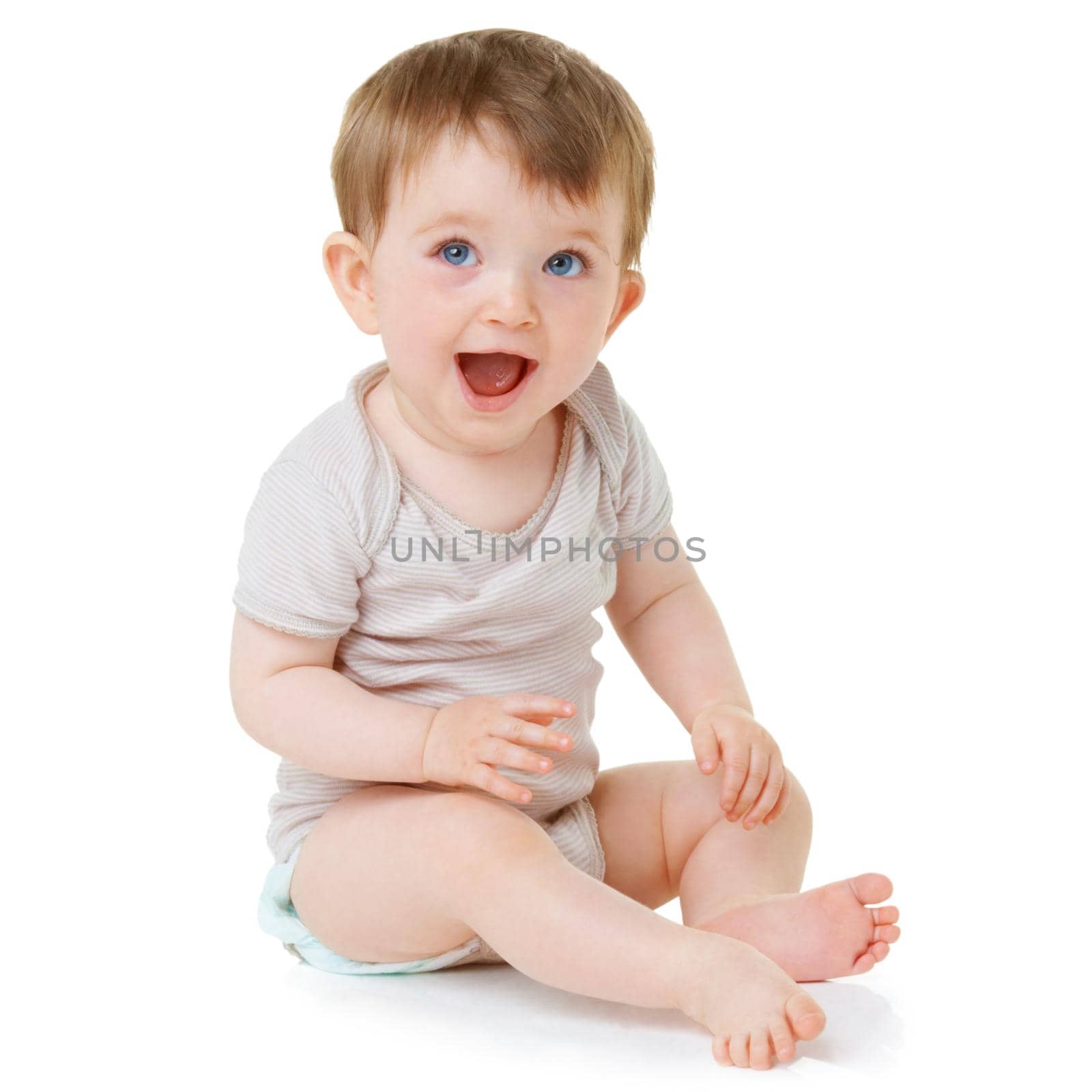 An adorable baby sitting down and laughing isolated on white.