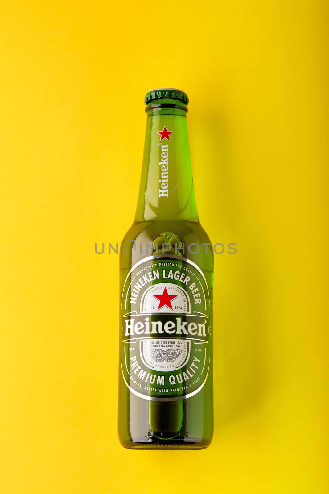 Bottle of Heineken Lager Beer on yellow background. Heineken is the flagship product of Heineken International. the world's most popular beer. 13.03.2020, Russia. by EvgeniyQW