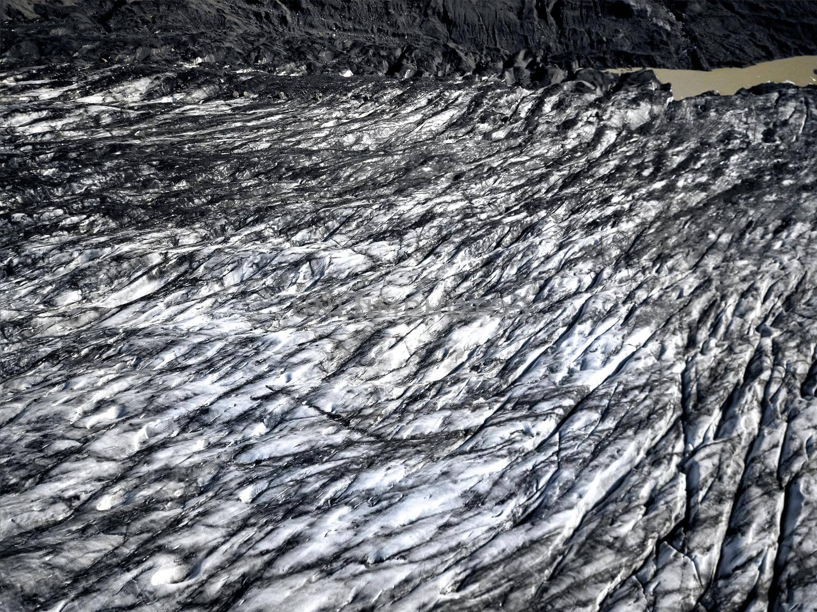 Aerial view of glacier from above, ice and ashes of the volcano texture landscape, beautiful nature ice background from Iceland