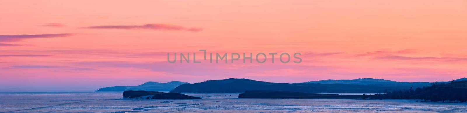 Frozen lake Baikal, at dawn. Winter landscape panorama