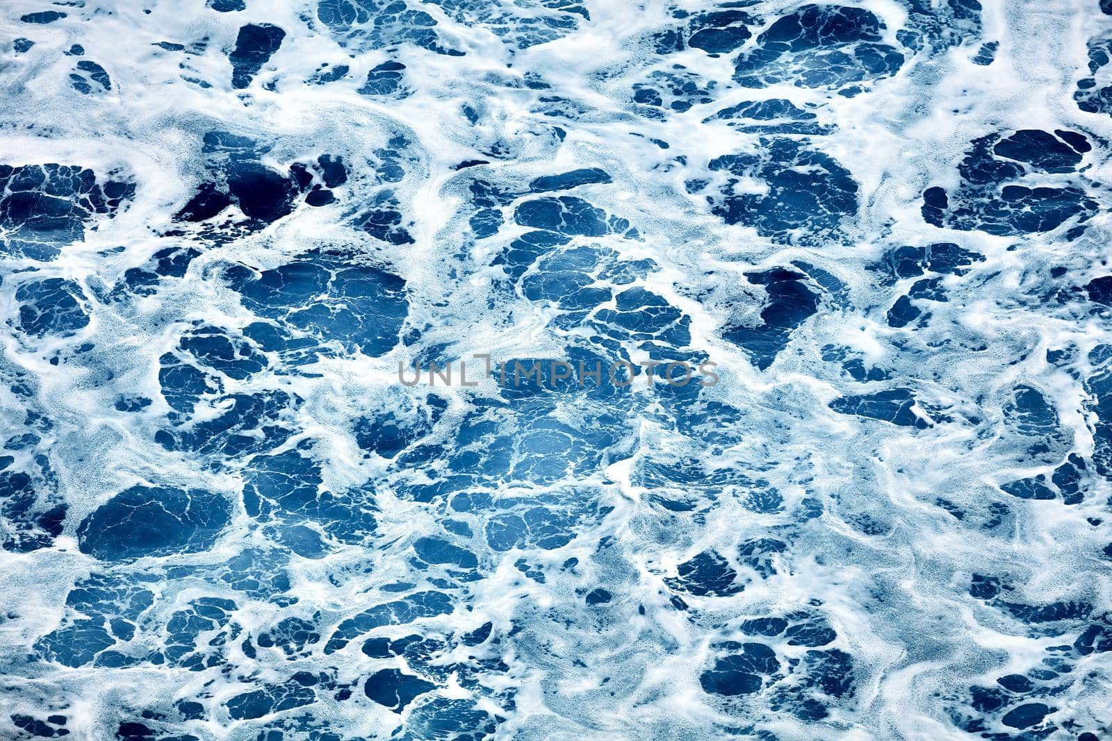 Rough sea close up. Beautiful blue waves with a lot of sea foam scene looked from above, close up. foam on the blue sea. Beauty world.