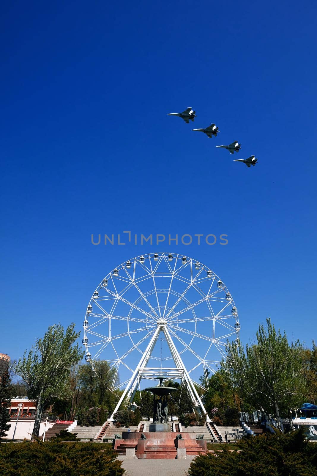 Rehearsal of the air parade in honor of the 75th anniversary of the end of World war II. Flying aircraft on the background of the Ferris wheel on theater square. 30.04.2020, Rostov-on-Don, Russia. by EvgeniyQW