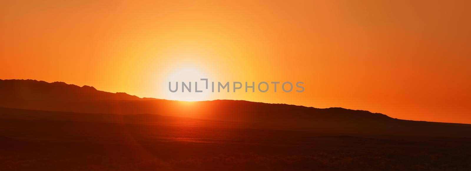 Beautiful Sunrise over the mountains Contour of the mountains, orange dawn. Disk of the sun and the first rays of the sun.