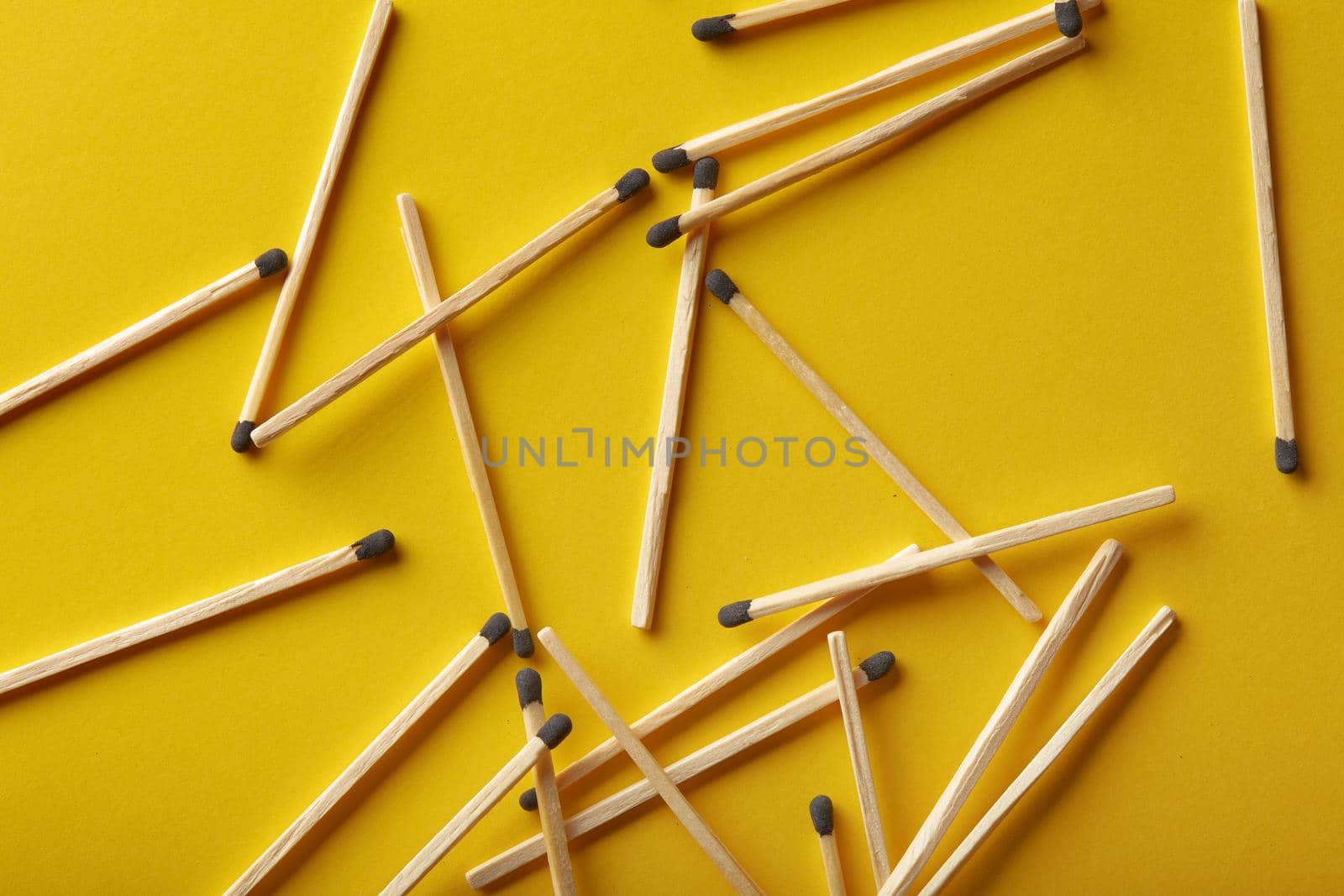 Matches on a yellow background, an abstraction about teamwork and modern relationships.