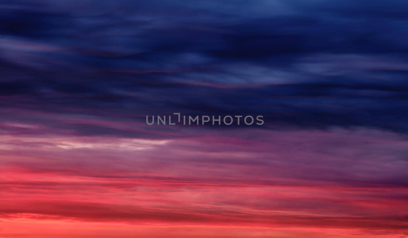 Colorful sunset with clouds in the evening. Abstract nature background. Dramatic and moody pink, purple and blue cloudy sunset sky.