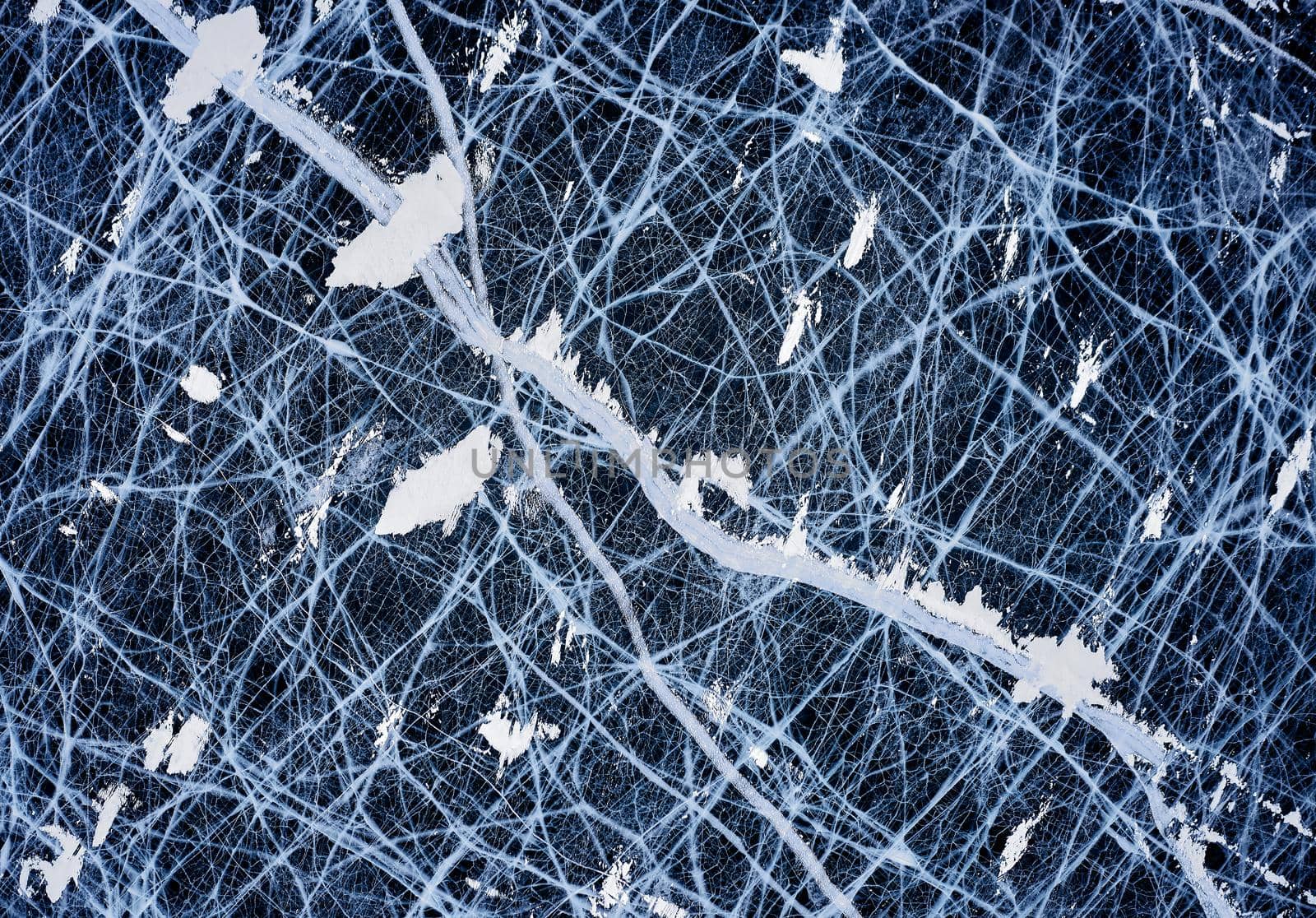 Deep blue ice - aerial view. Aesthetics of ice. frozen lake. Clean water texture of ice. View of beautiful drawings on ice, Baikal lake in winter