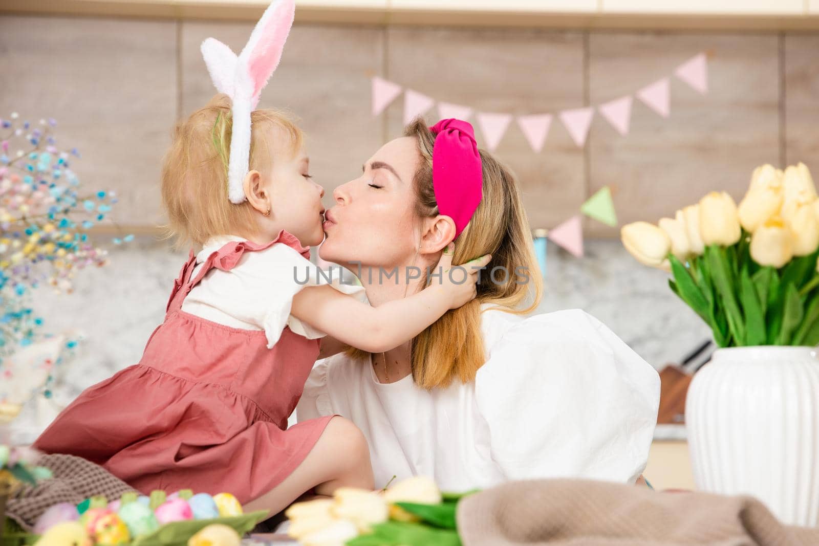 Happy Family preparing for Easter. Cute girl kissing mother. Home activity. Concept of unity and love. Mom and daughter by Marina-A