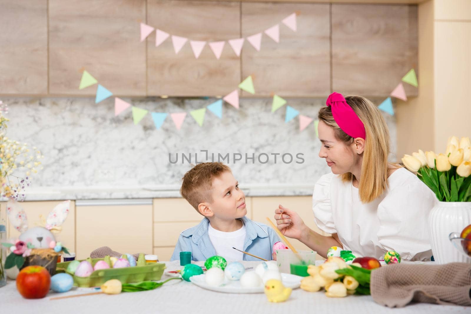 Big Happy Family preparing for Easter. Cute child with mother painting eggs. Home activity. Concept of unity and love. Mom and son.