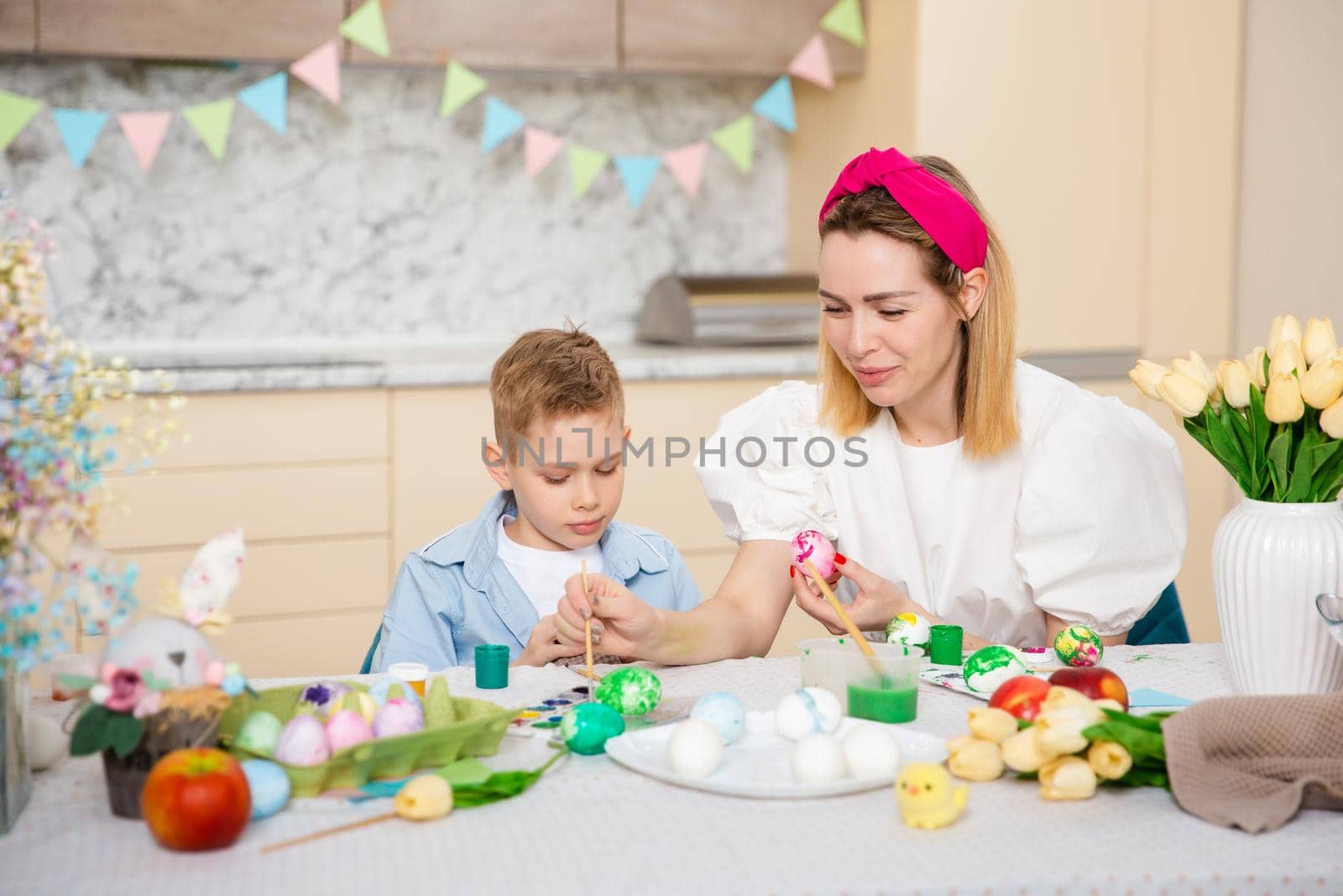 Big Happy Family preparing for Easter. Cute child with mother painting eggs. Home activity. Concept of unity and love. Mom and son.