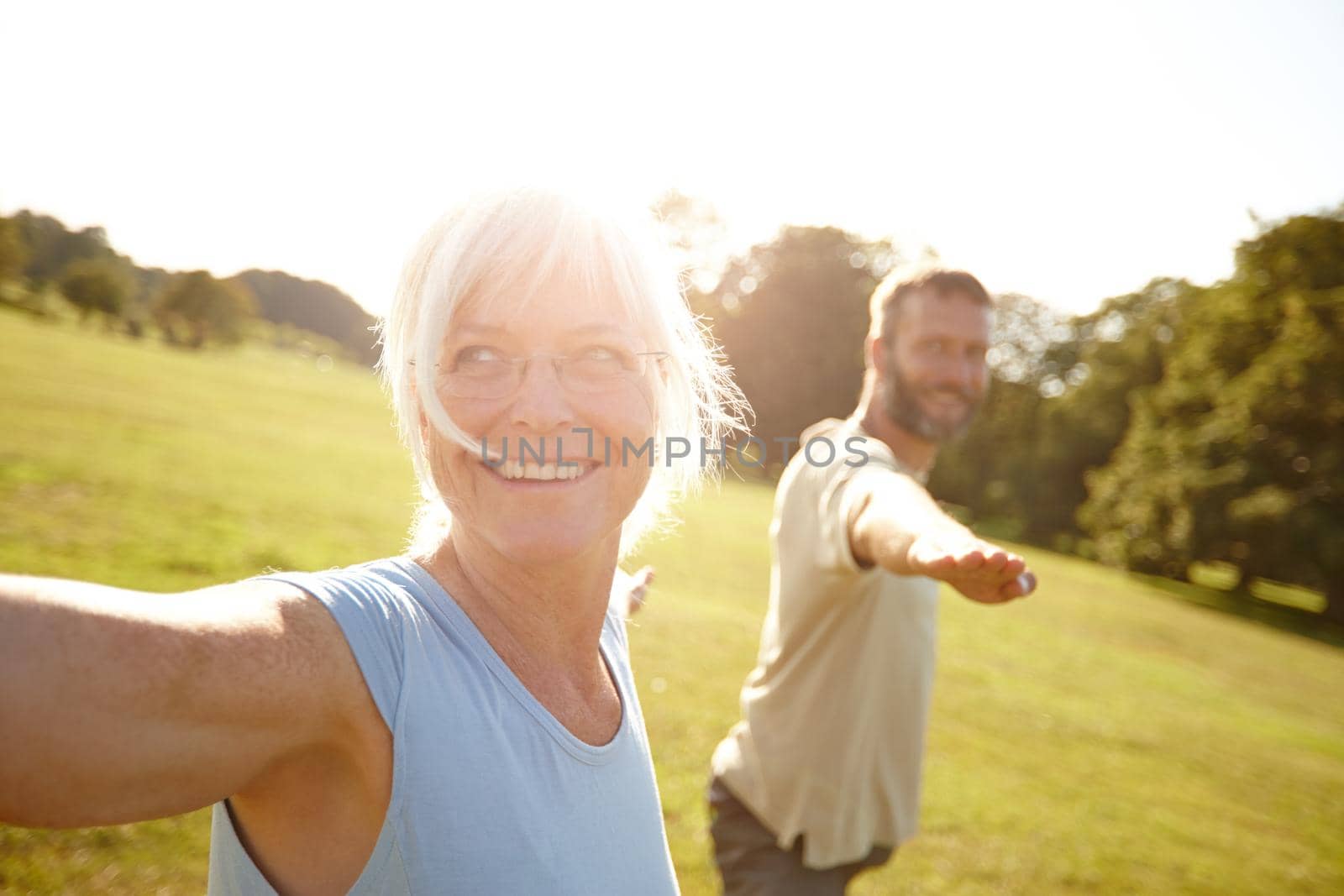 Yoga - something they both enjoy. Shot of a happy mature couple doing yoga together outdoors. by YuriArcurs