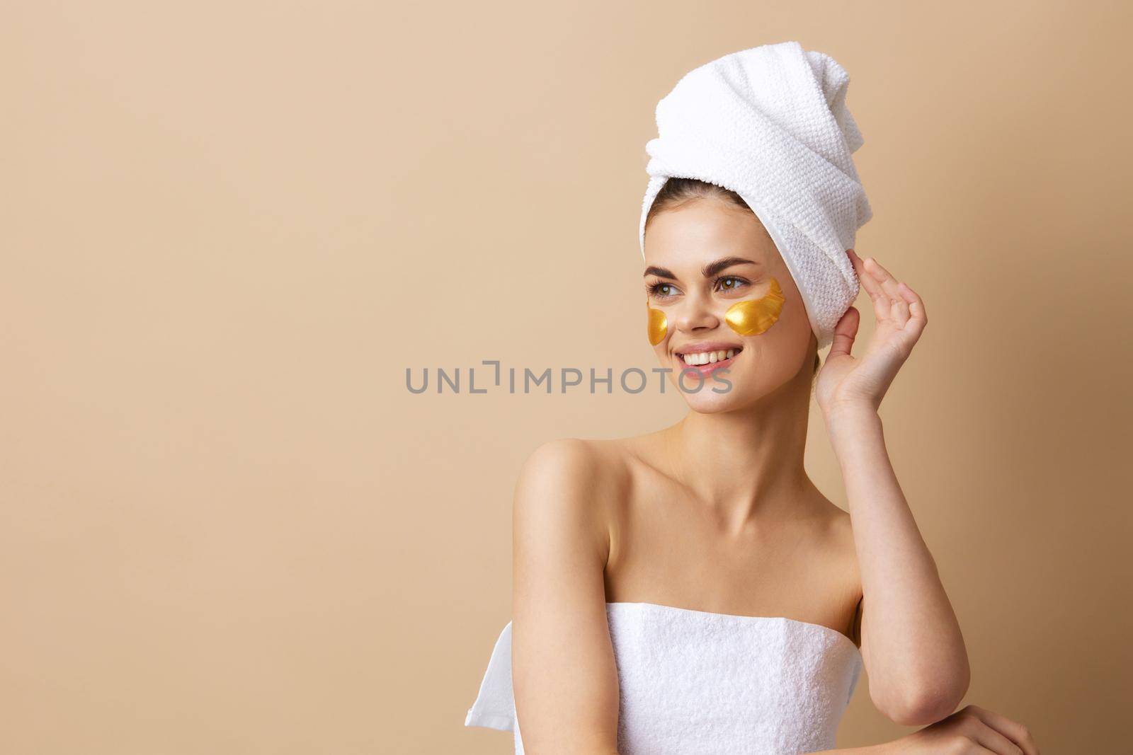 young woman with a towel on his head gesturing with his hands skin care close-up Lifestyle. High quality photo