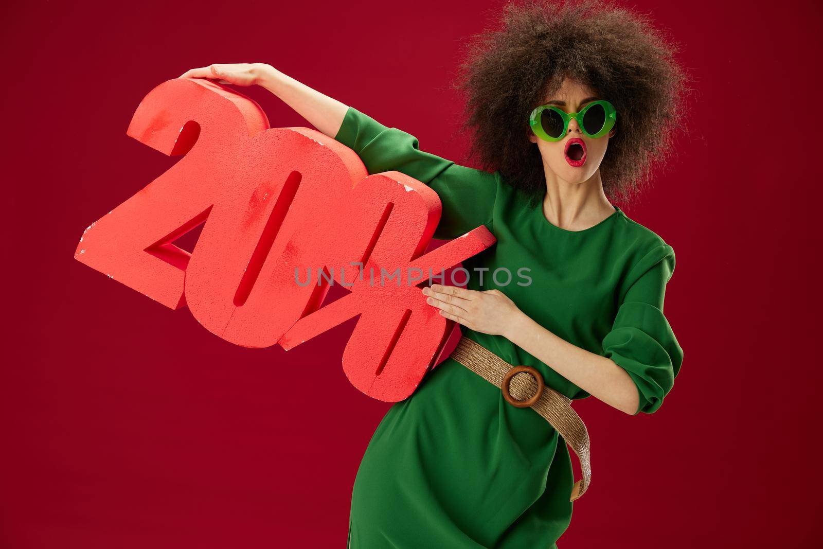 pretty woman green dress afro hairstyle dark glasses twenty percent in hands color background unaltered. High quality photo